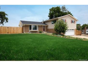 Charming home boasts a well-manicured lawn and inviting curb appeal at 7210 Otis Ct, Arvada, CO 80003