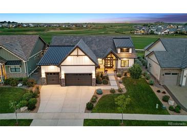 Charming home with a three-car garage, professional landscaping and a sprawling green lawn at 2932 Heron Lakes Pkwy, Berthoud, CO 80513
