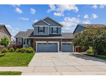 Charming two-story home with a brick facade, well-maintained lawn, and a spacious three-car garage at 25850 E 3Rd Ave, Aurora, CO 80018