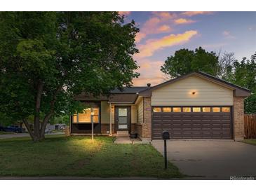 Charming single-Gathering home featuring a well-manicured lawn and an attached two-car garage at dusk at 5991 W 68Th Ave, Arvada, CO 80003