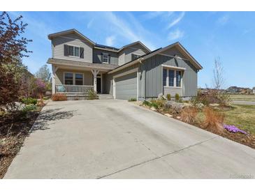 Charming two-story home featuring a covered porch, manicured landscaping, and an attached two-car garage at 1794 Wright Dr, Erie, CO 80516