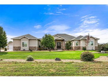 Ranch style home with stone accents and a landscaped lawn at 17155 Primrose Ln, Mead, CO 80542