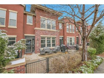 Charming red brick townhome with a cozy outdoor patio and seating area at 8977 E Otero Pl, Centennial, CO 80112