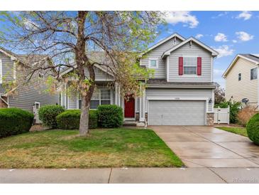 Charming two-story home with a well-manicured lawn, complemented by a red front door and inviting curb appeal at 6519 Eastview St, Longmont, CO 80504
