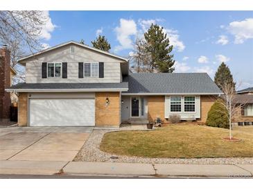 Charming two-story home with a brick facade, attached two-car garage, and manicured front yard at 8005 W Calhoun Pl, Littleton, CO 80123