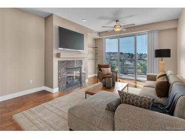 Bright living room with fireplace, TV, and balcony access offers a relaxing and modern living space at 9019 E Panorama Cir # D217, Englewood, CO 80112