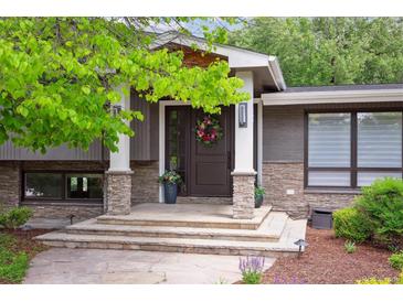 Inviting front door with stone accents, white pillars, and colorful floral wreath detail at 5752 S Jasmine St, Greenwood Village, CO 80111