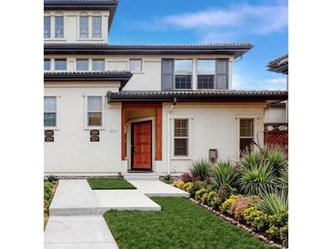 Two-story townhome with a welcoming front porch and landscaped yard at 2274 Valentia St, Denver, CO 80238