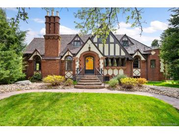 Charming Tudor home boasts a red brick facade, manicured lawn, and a unique chimney design at 1930 E 8Th Ave, Denver, CO 80206