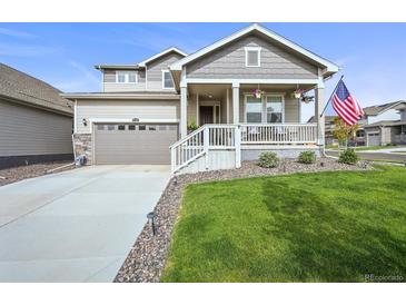 Charming home featuring a quaint front porch, well-manicured lawn, and an attached two-car garage at 17765 Faraday St, Broomfield, CO 80023