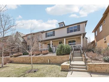 Charming two-story home with stone accents, landscaped yard, and inviting front porch at 8977 Crossington Way, Lone Tree, CO 80124
