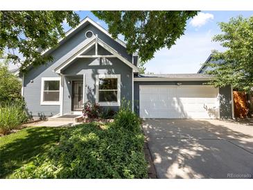 Charming home with a well-manicured lawn, lovely landscaping, and an attached two-car garage at 4860 S Salida Ct, Aurora, CO 80015
