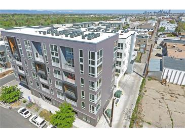 Modern apartment building with sleek gray facade, balconies, and a rooftop filled with HVAC units at 1898 S Bannock St # 103, Denver, CO 80223