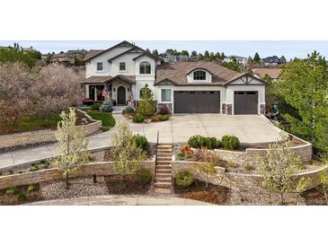 Beautiful two-story stucco home with a three-car garage and professionally landscaped front yard at 947 Buffalo Ridge Rd, Castle Pines, CO 80108