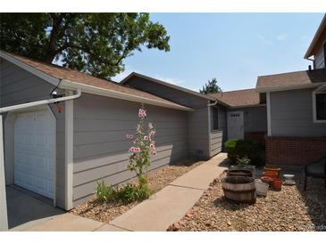 Gray townhouse exterior with a walkway, landscaping, and attached garage at 522 W Crestline Cir # 8A3, Littleton, CO 80120