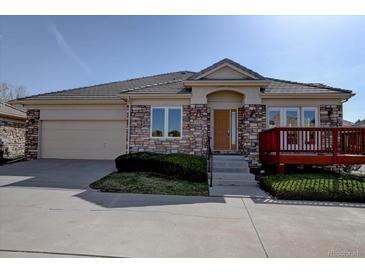 Charming single-story home featuring stone accents, a tile roof, and a cozy front deck at 13941 E Whitaker Dr, Aurora, CO 80015