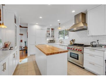 Bright kitchen features butcher block island, stainless steel appliances, white cabinetry, and subway tile backsplash at 160 Bristlecone Way, Boulder, CO 80304