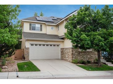 Two story home featuring stone accents, attached two car garage and well maintained lawn at 10696 Riverbrook Cir, Highlands Ranch, CO 80126