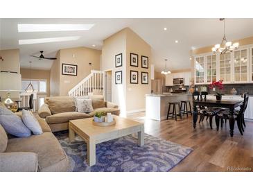 Inviting living room showcasing an open concept, seamless flow, and lots of natural light from skylights at 6376 S Glencoe Ct, Centennial, CO 80121