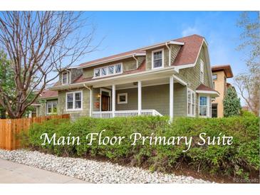 Charming two-story home featuring a welcoming front porch and landscaped front yard with mature hedges at 2595 S Adams St, Denver, CO 80210