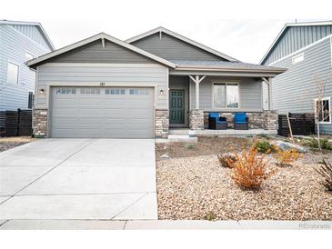 Charming single-story home with a two-car garage and a cozy front porch with stone accents at 121 S Vandriver Way, Aurora, CO 80018