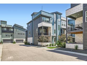 Modern townhome with stylish architecture, blue and white color scheme, and well-maintained landscaping at 6791 Navajo Ct, Denver, CO 80221