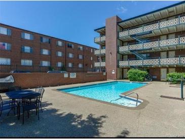 Relaxing pool with lounge chairs and community building in the background on a bright sunny day at 655 N Pearl St # 208, Denver, CO 80203