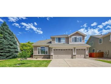 Charming two-story home with a well-manicured lawn and a three car garage at 17826 E Cloudberry Dr, Parker, CO 80134