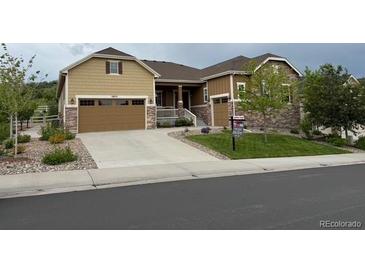 Inviting exterior of a two-story home with a well-manicured lawn, stone accents, and a spacious two-car garage at 3855 Old Oaks St, Castle Rock, CO 80104