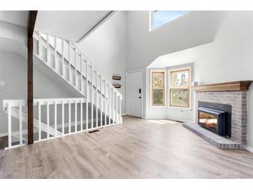 Inviting living room features a fireplace, white staircase, and plenty of natural light at 1740 S Ammons St # C, Lakewood, CO 80232