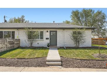Charming home featuring a white brick facade, well-maintained lawn, and a neatly landscaped front yard at 1087 Wolff St, Denver, CO 80204