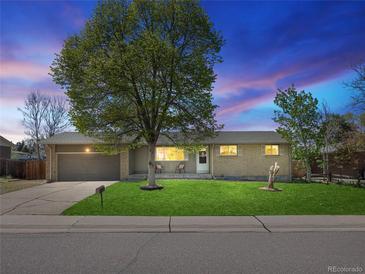 Charming single-story home featuring a well-maintained lawn, large shade tree and an attached two-car garage at 4779 S Owens Way, Littleton, CO 80127