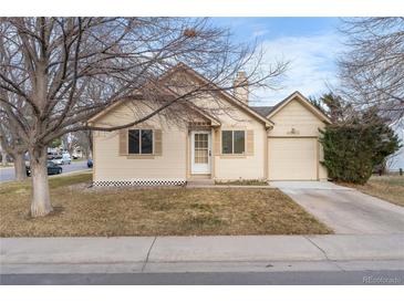 Tan single-story home with a manicured lawn and attached one car garage at 4552 S Buckley Way, Aurora, CO 80015