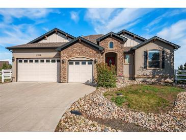 Charming two-story home featuring a stone facade, three-car garage, and well-manicured landscaping at 7998 Faith Ct, Frederick, CO 80530