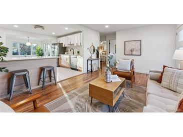 Bright living room with hardwood floors and mid-century modern furniture at 3307 Teller St, Wheat Ridge, CO 80033