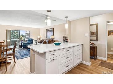 Bright kitchen island with white countertops and storage, seamlessly connected to the living area for open-concept living at 13961 E Marina Dr # 414, Aurora, CO 80014