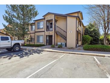 Inviting condo exterior with stone accents, private balcony, reserved parking, and lush landscaping at 4875 S Balsam Way # 6-102, Littleton, CO 80123