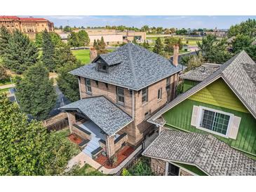 An elevated exterior shows the architectural details and new roof of this lovely brick home at 2854 Eliot St, Denver, CO 80211