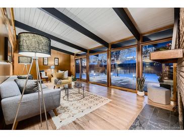 Bright living room with floor-to-ceiling windows and views of the snow covered backyard at 6127 S Westview St, Littleton, CO 80120