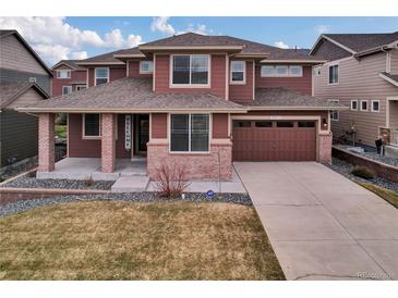 Inviting two-story home with brick and siding, a welcoming front porch, and a two-car garage at 20830 Scenic Park Dr, Parker, CO 80138