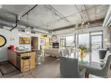 Open-concept living area with modern design, exposed ductwork, and city views at 2100 16Th St # 606, Denver, CO 80202