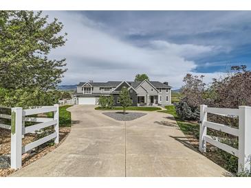 Stunning two-story home with circular driveway and white fencing at 7401 Deerfield Rd, Longmont, CO 80503