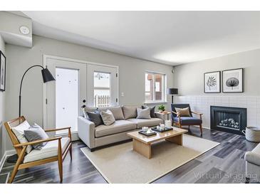 Bright living room with a fireplace, stylish furnishings, and a walk-out patio at 1202 S Troy St, Aurora, CO 80012