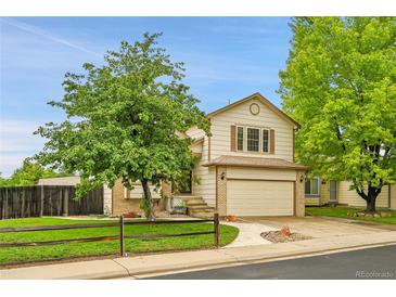 Charming two-story home features a well-maintained front yard and attached two car garage at 13008 Grove Way, Broomfield, CO 80020