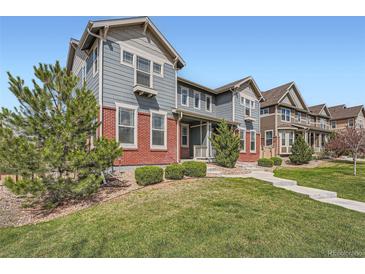 Charming two-story home featuring a well-maintained lawn and partial brick facade under a clear blue sky at 14732 E Poundstone Dr, Aurora, CO 80015