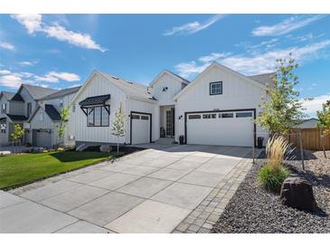Attractive white home with a large driveway and two-car garage at 6456 Kenzie Cir, Castle Pines, CO 80108