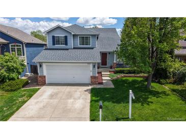 Charming two-story home featuring a two-car garage and a well-manicured lawn at 13464 Vine St, Thornton, CO 80241