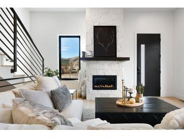 Bright living room with a stone fireplace, modern black windows, and a comfortable sectional sofa at 19 Washington Ave, Golden, CO 80403
