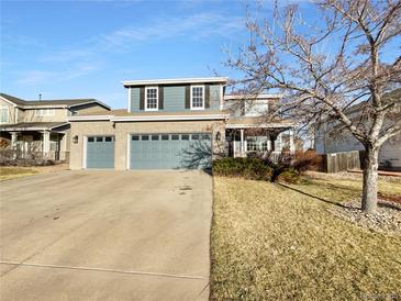 Charming two-story home with a brick facade, large garage, and well-maintained lawn at 13058 Monaco Way, Thornton, CO 80602