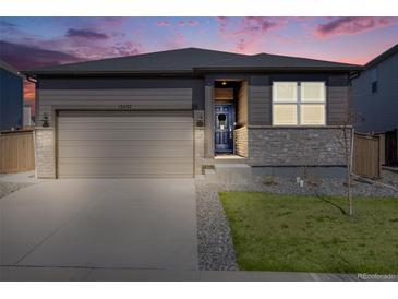 Charming single-Gathering home featuring a two-car garage, well-manicured lawn, and stylish gray exterior at 13437 Waterthrush St, Parker, CO 80134